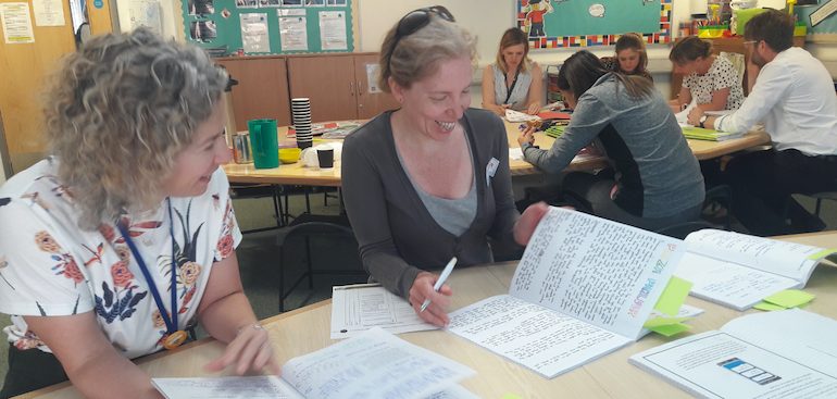 two teachers reviewing books as part of a science moderation meeting