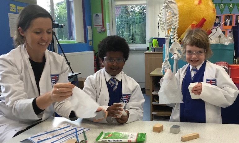 Pupils held to disinfect the equipment they have used for their practical science.