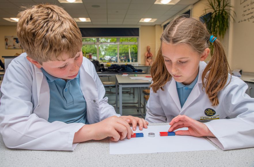 a boy and a girl learn about forces with a magnet investigation