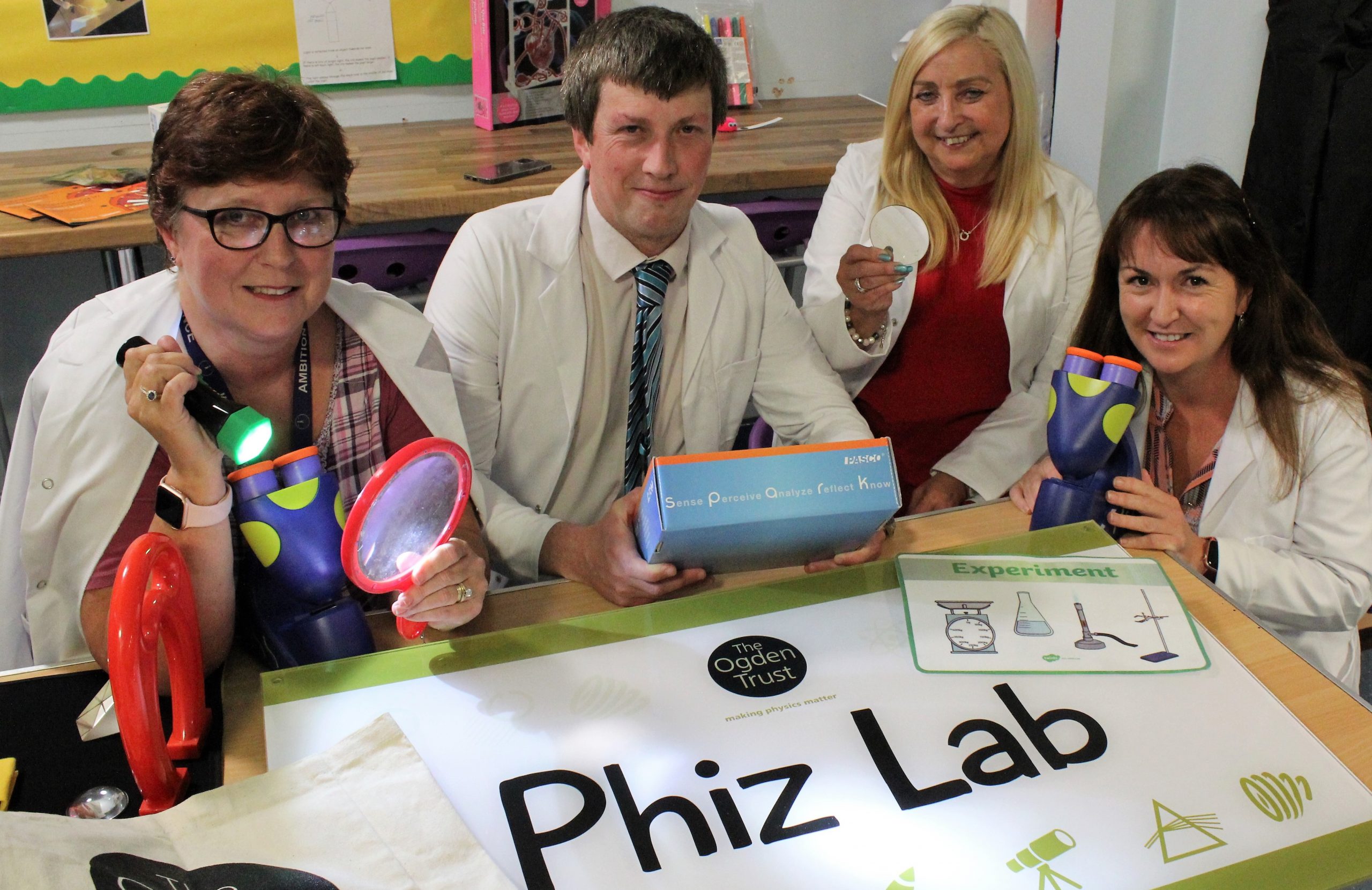 A photo from the Phiz Lab opening - seated around the Phiz Lab sign which is on a table
