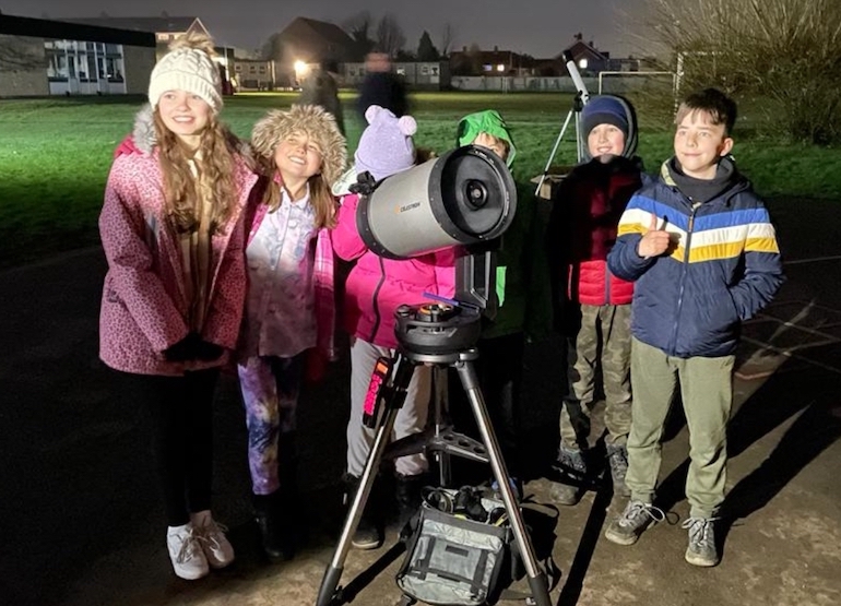 a group of children are pictured with a telescope